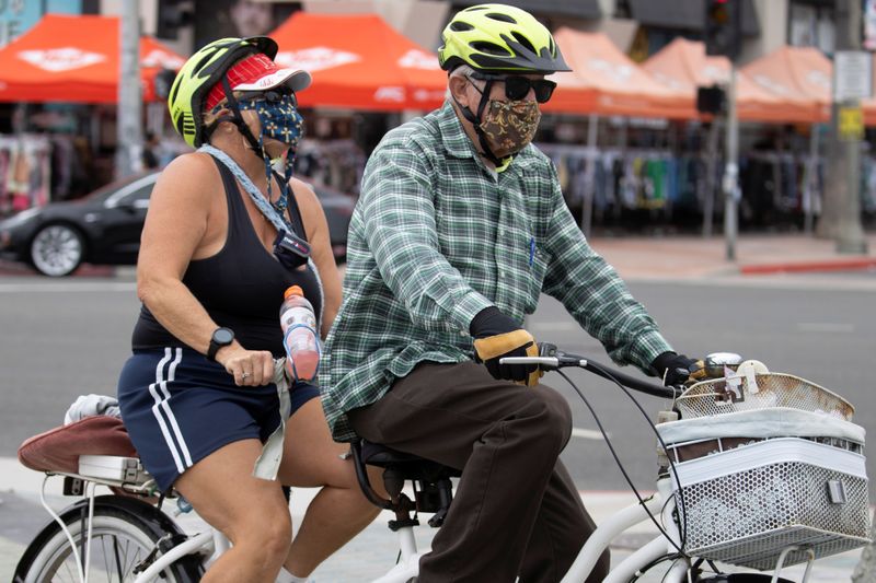 &copy; Reuters. Casal de bicicleta em Huntington Beach, na Califórnia