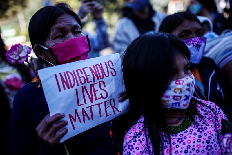 &copy; Reuters. FOTO DE ARCHIVO-Manifestantes con máscarillas protestan frente a un batallón militar, por la supuesta violación de una niña indígena Embera Chami por parte de soldados, en Bogotá, Colombia.