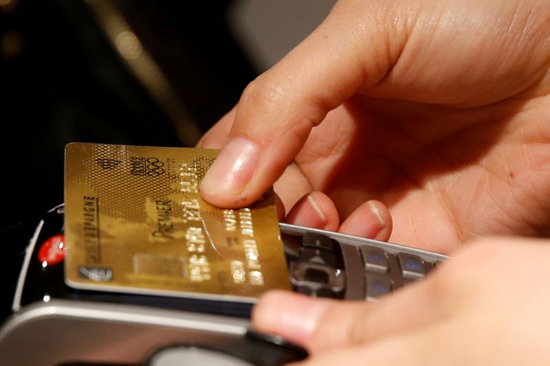 &copy; Reuters. FILE PHOTO: A customer pays with a credit card at a store in Paris