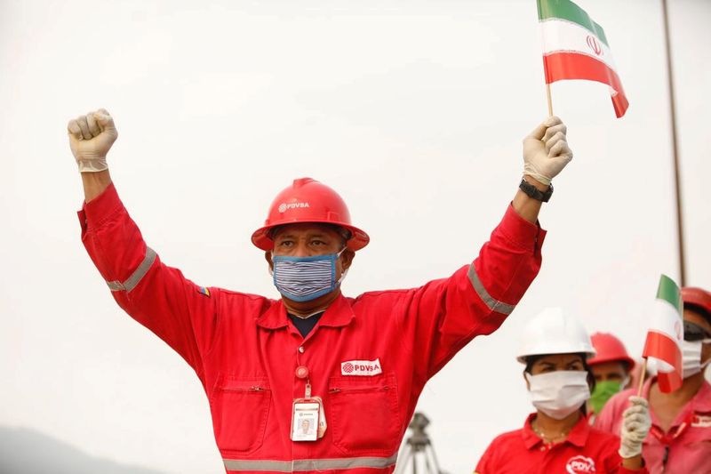 &copy; Reuters. IMAGEN DE ARCHIVO. Un trabajador de la petrolera estatal venezolana PDVSA sostiene una bandera de Irán durante la llegada de un tanquero iraní a la refinería El Palito, en Puerto Cabello, en Venezuela