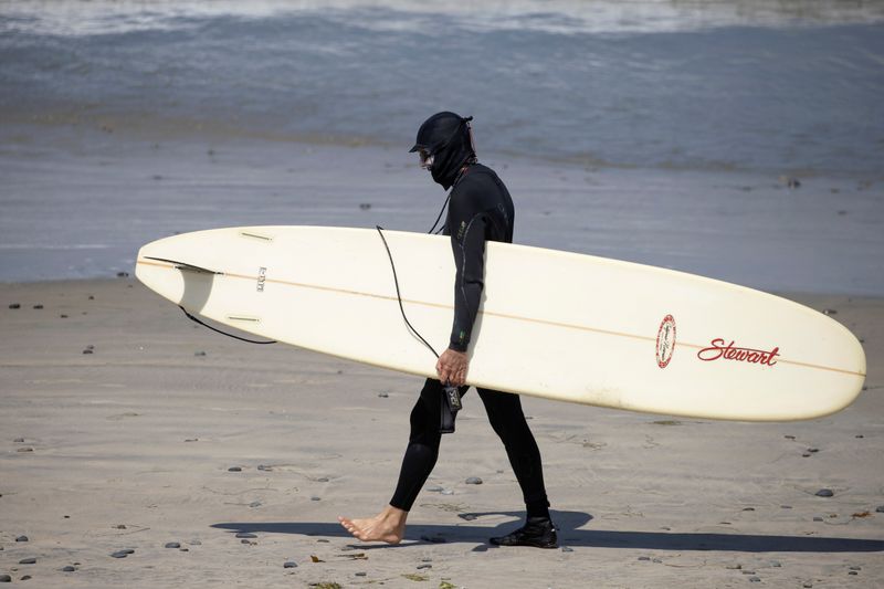 &copy; Reuters. Серфингист в маске во время пандемии COVID-19, Сан-Диего, Калифорния