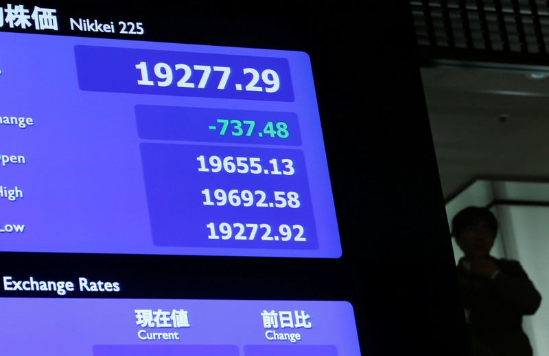 &copy; Reuters. Un uomo vicino a un cartellone elettronico che indica l&apos;andamento dei titoli presso la borsa di Tokyo, 4 gennaio 2019