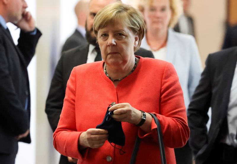 &copy; Reuters. La cancelliera tedesca Angela Merkel tiene in mano una mascherina mentre esce da un vertice del Consiglio federale tedesco