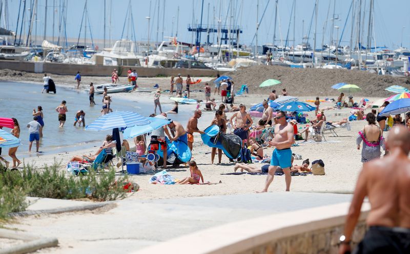 © Reuters. FILE PHOTO: People sunbathe on Playa de Palma beach in Mallorca