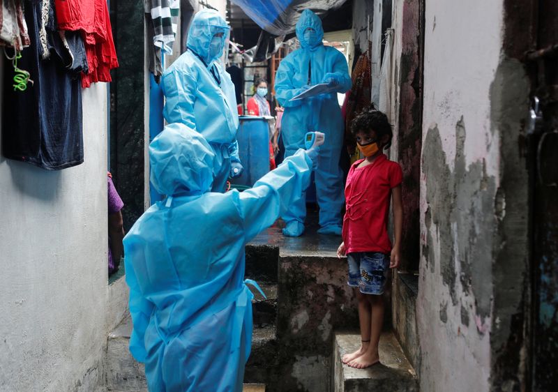 &copy; Reuters. Agentes de saúde medem temperatura de criança em comunidade carente em Mumbai