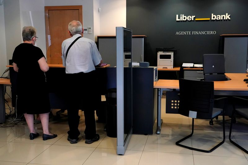 © Reuters. Clientes en una sucursal de la agencia financiera Liberbank en Madrid, España