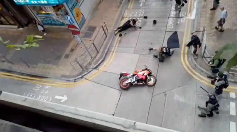 © Reuters. A motorcyclist crashes into police officers in Wan Chai near Gloucester Road in Hong Kong