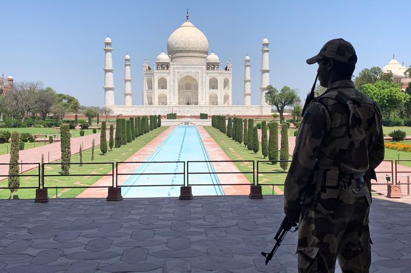 &copy; Reuters. FILE PHOTO: A member of Central Industrial Security Force (CISF) personnel stands guard inside the empty premises of the historic Taj Mahal during a 21-day nationwide lockdown