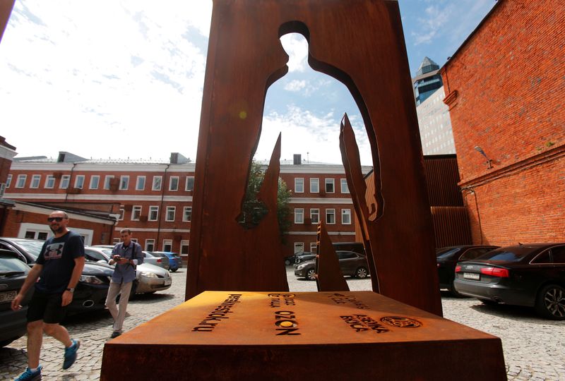 &copy; Reuters. People walk past a monument honouring delivery couriers who continued to work throughout the outbreak of the coronavirus disease (COVID-19), in Moscow