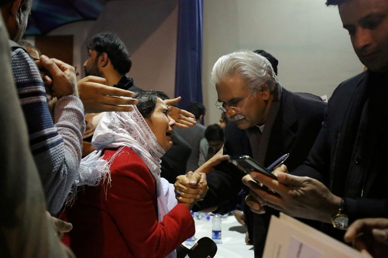 &copy; Reuters. Pakistan&apos;s Health Minister, Zafar Mirza, interacts with the mother of a Pakistani student, who is stuck in the locked down Hubei province at the center of China&apos;s coronavirus outbreak, as pepople demand evacuation of their children in Islamabad