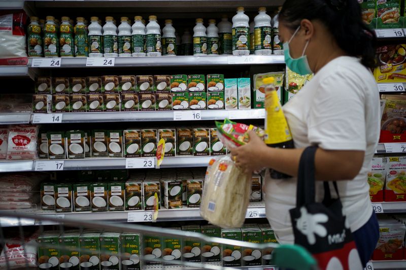 &copy; Reuters. A woman shops coconut products at a supermarket in Bangkok