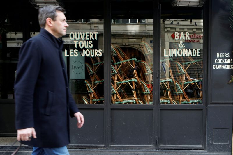 © Reuters. FILE PHOTO: A man walks past closed restaurant, as France grapples with an outbreak of coronavirus (COVID-19) disease, in Paris