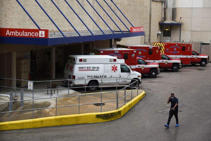 &copy; Reuters. FOTO DE ARCHIVO: Un trabajador médico pasa junto a una fila de ambulancias estacionadas afuera del Hospital Metodista de Houston mientras las nubes de tormenta se acumulan sobre el Centro Médico de Texas, en medio del brote global de  coronavirus en Hou