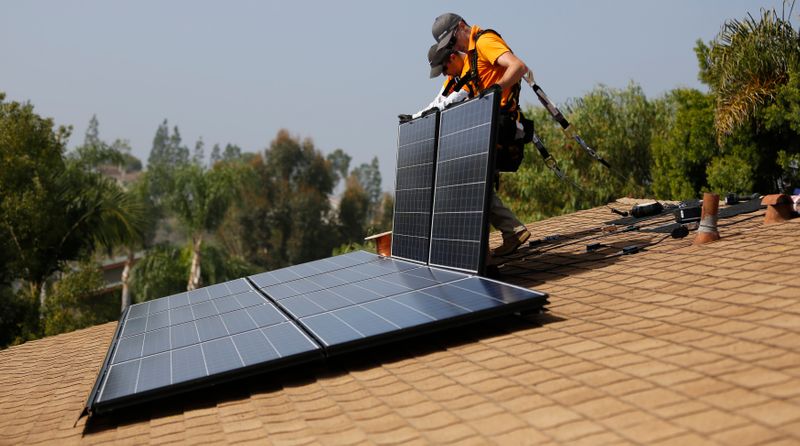 &copy; Reuters. Vivint Solar technicians install solar panels on the roof of a house in Mission Viejo