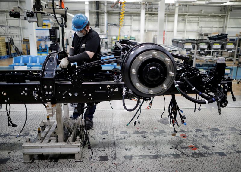 &copy; Reuters. FILE PHOTO: An employee wearing a protective face mask and face guard works on the automobile assembly line during the outbreak of the coronavirus disease (COVID-19) at the factory of Mitsubishi Fuso Truck and Bus Corp. in Kawasaki