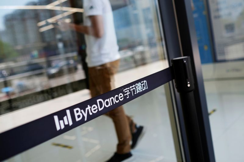 © Reuters. Man walks by a logo of Bytedance, which owns short video app TikTok, at its office in Beijing