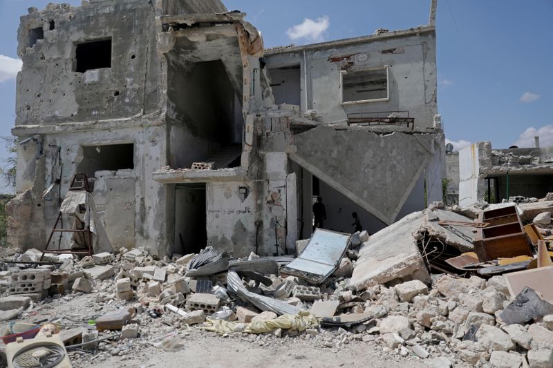 &copy; Reuters. FILE PHOTO: Saher al-Ali&apos;s family members stand inside their damaged house in the rebel-held town of Nairab