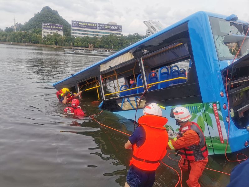 &copy; Reuters. Rescue workers are seen at the site where a bus carrying students plunged into a reservoir, in Anshun