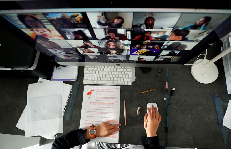 © Reuters. FILE PHOTO: A student takes classes online with his companions using the Zoom app at home