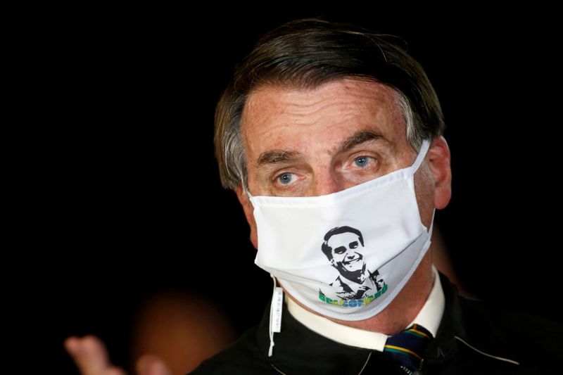 &copy; Reuters. FILE PHOTO: Brazil&apos;s President Jair Bolsonaro speaks with journalists while wearing a protective face mask as he arrives at Alvorada Palace, amid the coronavirus disease (COVID-19) outbreak, in Brasilia