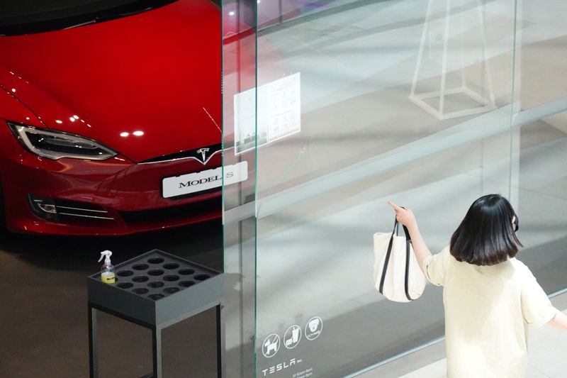 &copy; Reuters. A woman walks past a Tesla dealership in Hanam