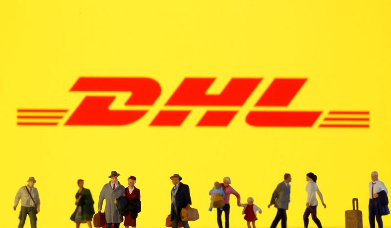 &copy; Reuters. Small toy figures are seen in front of diplayed DHL  logo