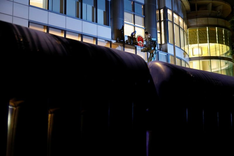 &copy; Reuters. Water filled barriers are seen surrounding the Metropark Hotel Causeway Bay Hong Kong, believed to be used by the temporary national security office, as workers place a national emblem at midnight, in Hong Kong