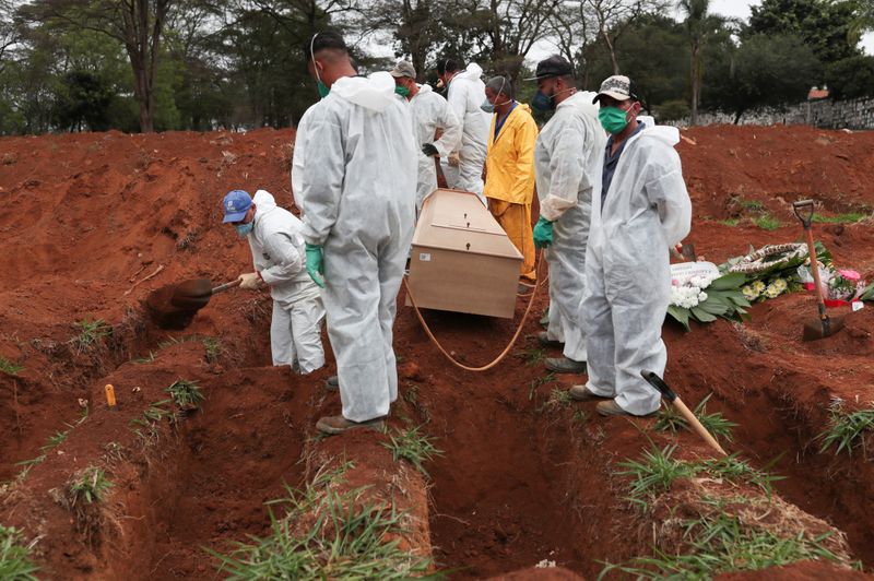 &copy; Reuters. FOTO DE ARCHIVO: Sepultureros con trajes protectores se preparan para enterrar el ataúd de una mujer de 63 años que murió por lCOVID-19 en el cementerio de Vila Formosa, en Sao Paulo, Brasil. 26 de junio de 2020.