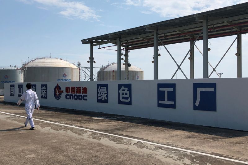 &copy; Reuters. FILE PHOTO: Worker walks past the logo of China National Offshore Oil Corporation (CNOOC) at its Nanshan liquefied natural gas (LNG) terminal in Hainan