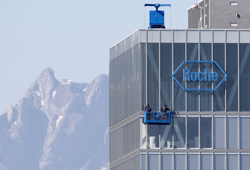 © Reuters. FILE PHOTO: Workers clean windows of a building of Roche in Rotkreuz