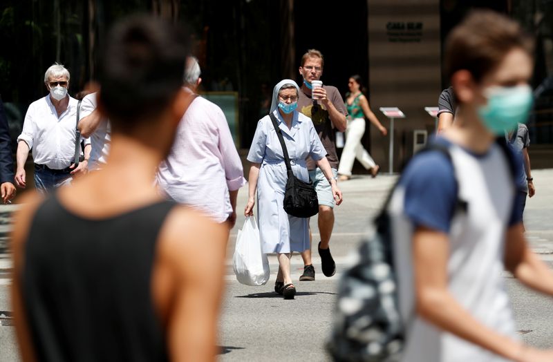 &copy; Reuters. Varias personas con mascarillas caminan por una calle de Barcelona