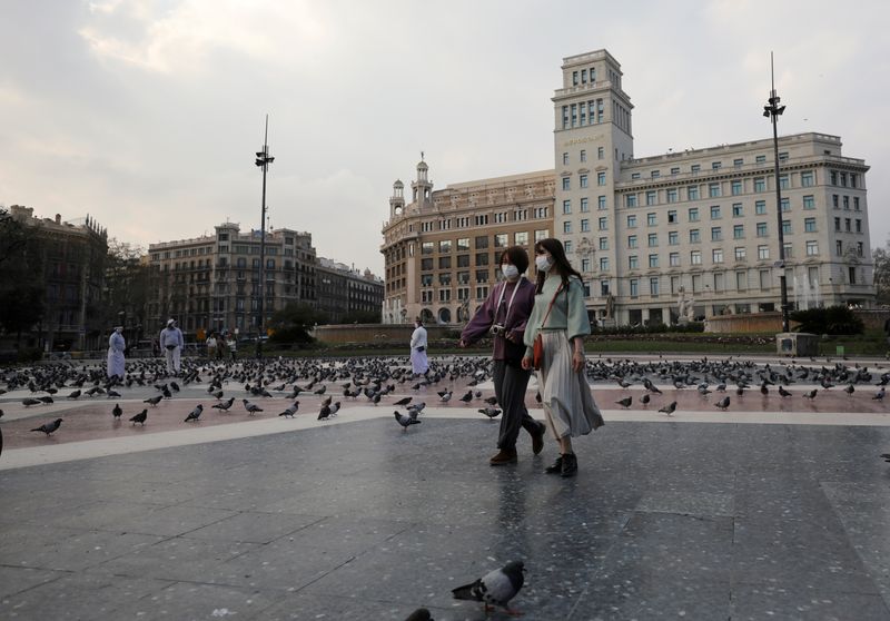 &copy; Reuters. Pessoas usam máscaras enquanto caminham na Plaza de Catalunya, em Barcelona