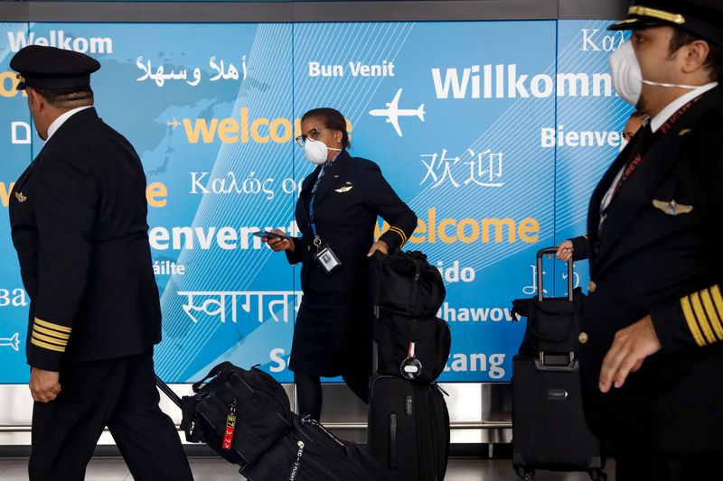 © Reuters. FILE PHOTO: Members of a flight crew wear face masks as they arrive at John F. Kennedy International Airport in New York