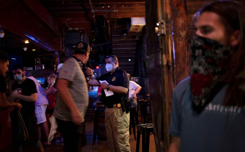 &copy; Reuters. FILE PHOTO: Agents from the Texas Alcoholic Beverage Commission check that bars are maintaining social distancing protocols  in Austin