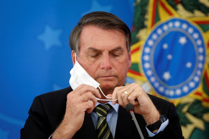 &copy; Reuters. FILE PHOTO: Brazil&apos;s President Jair Bolsonaro adjusts his protective face mask during a press statement to announce federal judiciary measures to curb the spread of the coronavirus disease (COVID-19) in Brasilia