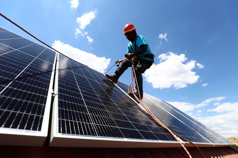 &copy; Reuters. Kauahou, a worker of the installation company Alromar, sets up solar panels on the roof of a home in Colmenar Viejo