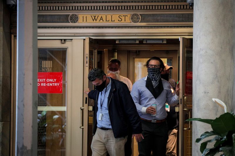 &copy; Reuters. Трейдеры в масках выходят из здания Нью-Йоркской фондовой биржи