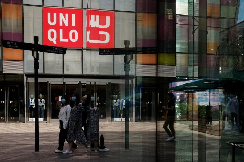 &copy; Reuters. FILE PHOTO: Women walk past a store of the Fast Retailing&apos;s fashion chain Uniqlo, in Beijing