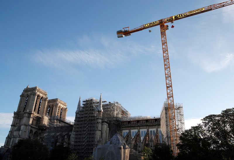 &copy; Reuters. Ativistas do Greenpeace exibem cartaz em Notre-Dame por ação imediata contra mudança climática