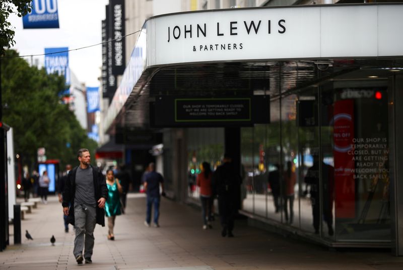 © Reuters. FILE PHOTO: A man walks past the John Lewis & Partners store at the Oxford Street, in London