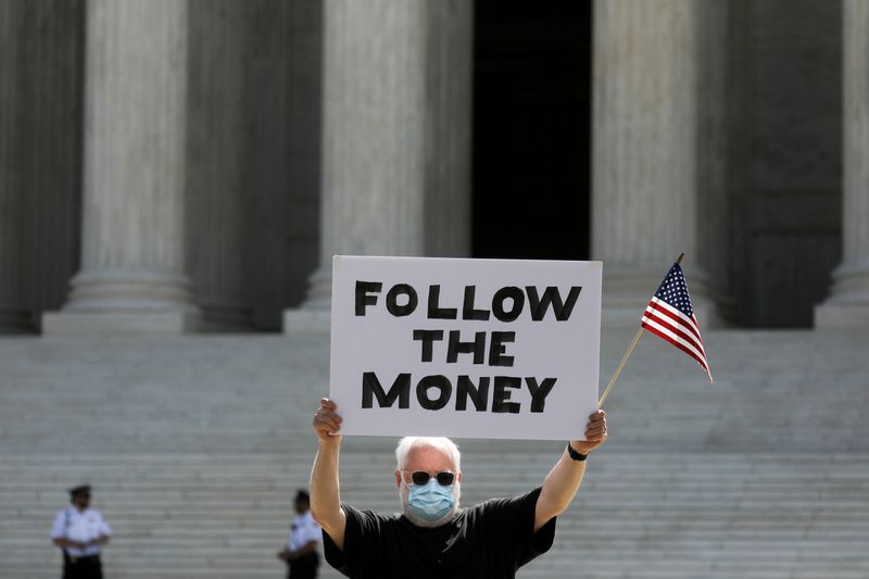 &copy; Reuters. El manifestante Bill Christeson sostiene un letrero que dice &quot;sigan el dinero&quot; frente a la Corte Suprema de Estados Unidos, donde los jueces dictaminaron que un fiscal en la ciudad de Nueva York puede obtener los registros financieros del presid