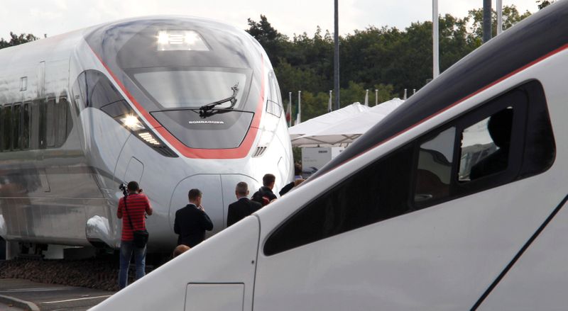 &copy; Reuters. FILE PHOTO: Visitors walk next to a Bombardier ZEFIRO 380 and a Alstom 4th generation Pendolino high speed trains at the Innotrans fair in Berlin