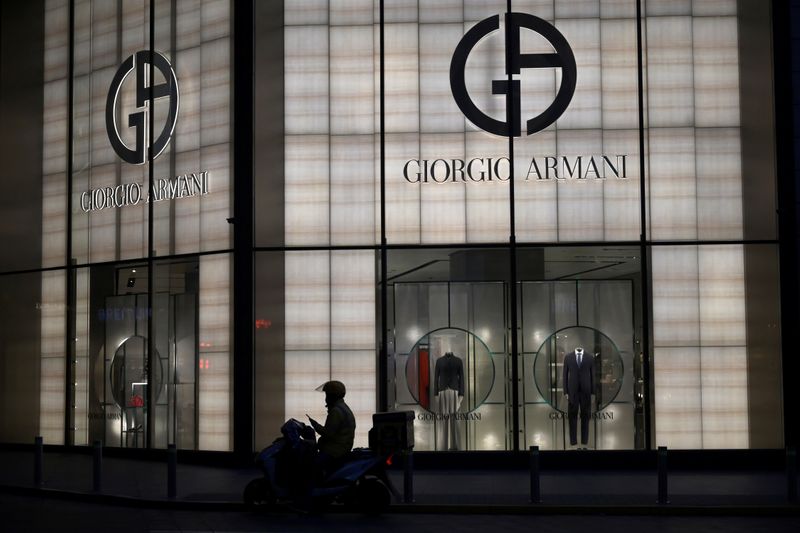 © Reuters. Deliveryman is seen silhouetted in front of Italian luxury brand Giorgio Armani's store in Beijing