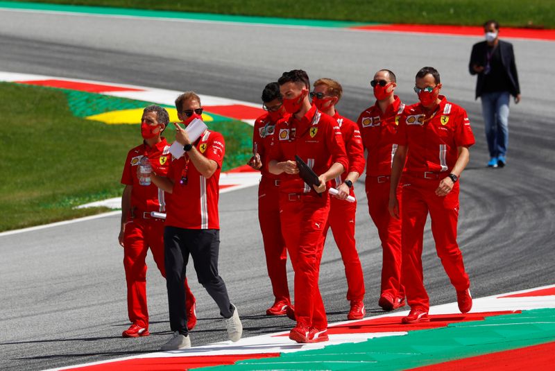 &copy; Reuters. Diversi membri del team Ferrari camminano sul circuito Red Bull Ring per il Gran Premio d&apos;Austria, indossando maschere protettive