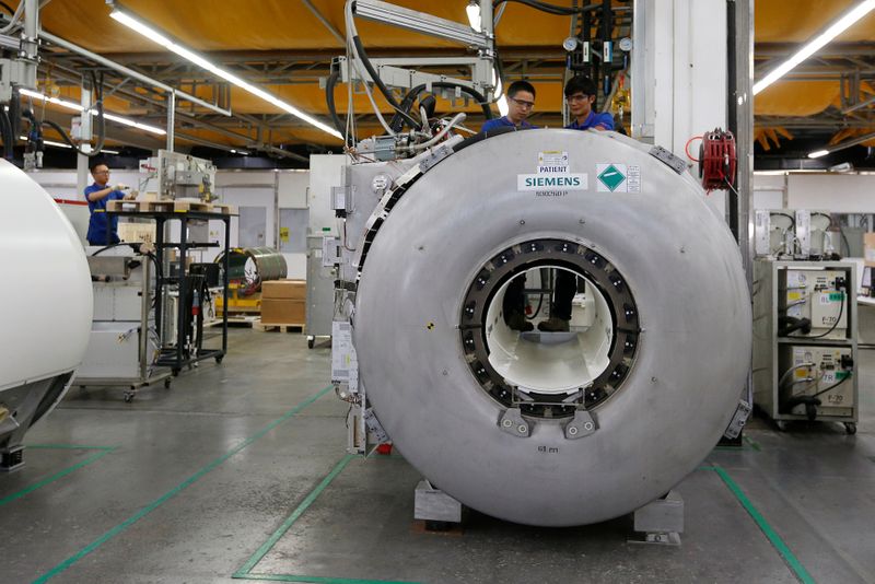 &copy; Reuters. Staff work on magnetic resonance imaging machines at a production line of Siemens Healthineers in Shenzhen