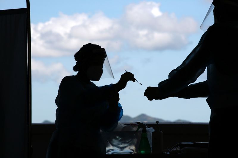 &copy; Reuters. FILE PHOTO: A health worker puts a swab sample from a taxi driver into a container for COVID-19 test at a makeshift testing station in a parking lot following the coronavirus disease (COVID-19) outbreak in Hong Kong