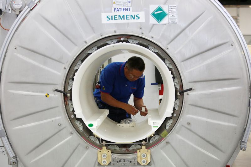 &copy; Reuters. A staffer works on a magnetic resonance imaging machine at a production line of Siemens Healthineers in Shenzhen