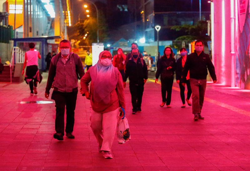 &copy; Reuters. FILE PHOTO: People wearing protective face masks walk during rush hour amid the spread of the coronavirus disease (COVID-19) outbreak in Jakarta