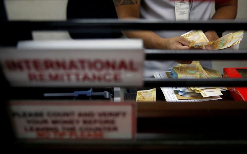 &copy; Reuters. FILE PHOTO: Teller counts Philippine peso bills at international money remittance center in Makati City