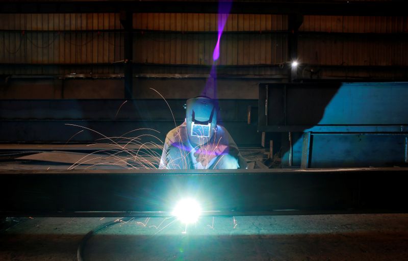 &copy; Reuters. A labourer welds an iron pillar at a building material factory in an industrial area in Dasna